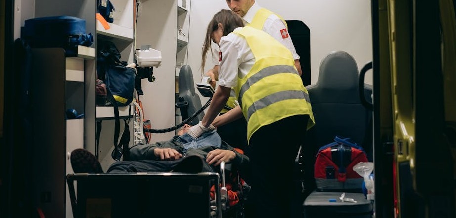 Emergency responders attend to an injured person at the scene of an accident, offering immediate medical support.